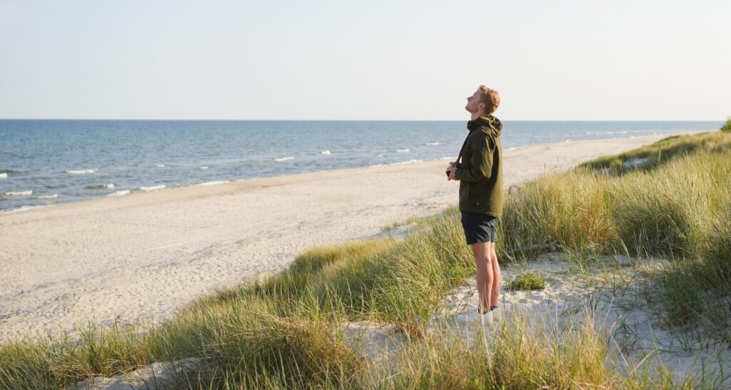 Mann atmet am Ostseestrand tief durch