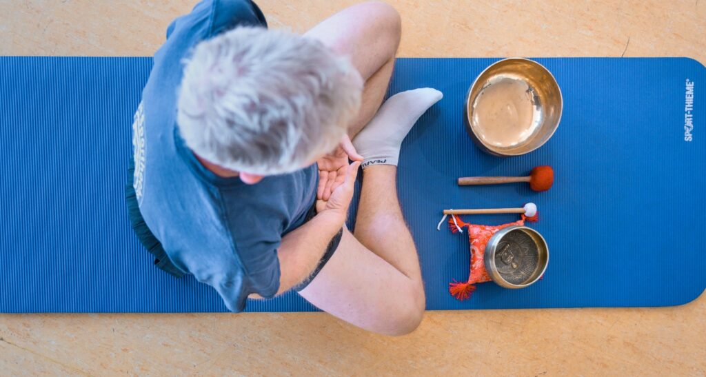Mann bei der Klangschalentherapie